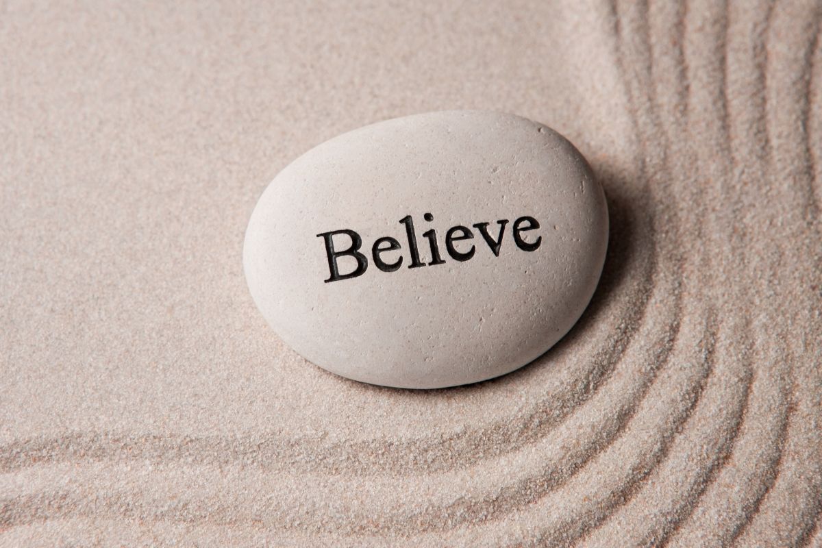 Stone engraved with the word Believe symbolizing faith and trust in Jesus.